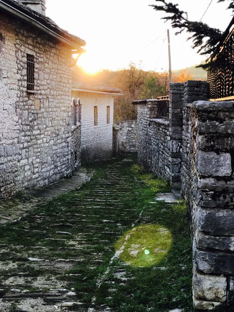 Sunset illuminating narrow stone alley in traditional village - Download Free Stock Images Pikwizard.com
