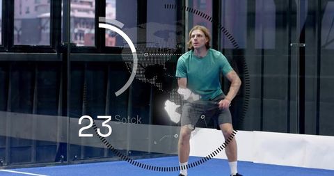 Male paddle athlete preparing to strike on urban padel court with hud data overlay