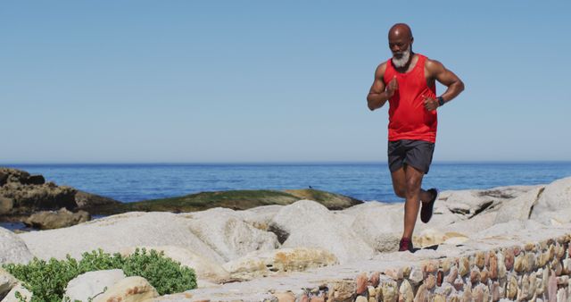 Active Senior Man Jogging By Sea On Sunny Day Wearing Red Tank - Download Free Stock Images Pikwizard.com