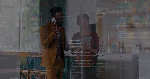 Talking coworkers collaborating in modern kitchen workspace with translucent code overlay