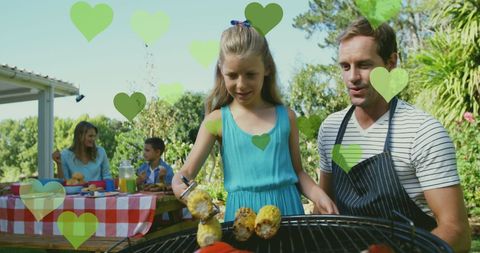Father and Daughter Grilling Corn at Family Picnic Gathering