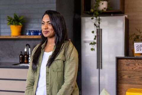 Indian woman standing in modern minimalist kitchen smiling mid-30s lifestyle portrait