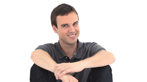 Smiling Young Man Sitting Relaxed on White Background