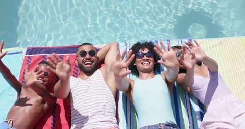 Happy Family Sunbathing Poolside Waving Energetically