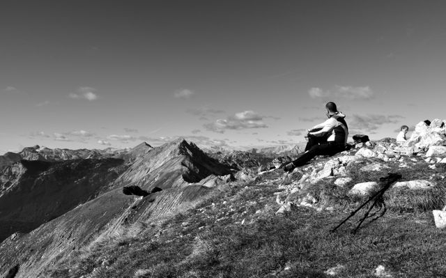 Hiker Sitting on Mountain Peak Admiring Scenic View in Black and White - Download Free Stock Images Pikwizard.com