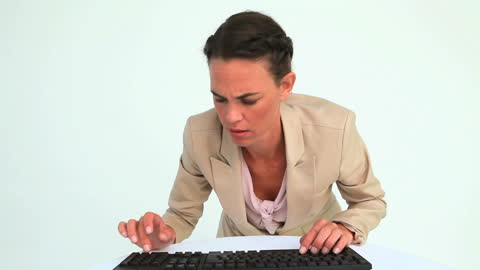 Focused Businesswoman in Formal Attire Typing on Keyboard