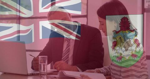 Businesspeople reviewing documents with bermuda flag overlay showing uk-bermuda partnership