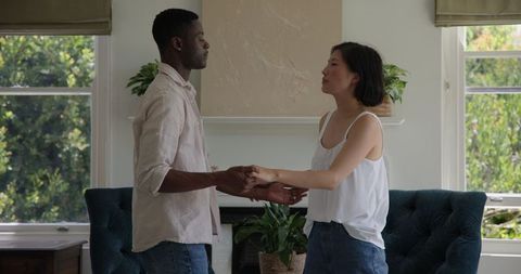Interracial Couple Embracing in Modern Living Room