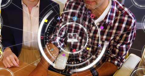 Team Collaborating Around Futuristic HUD Interface Over Desk with Laptop Icon and Analytics
