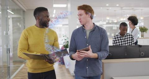 Colleagues walking and collaborating with tablet showing holographic ar data ribbon in office