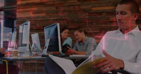 Man reviewing binder in creative coworking space with dslr and rustic wood monitors