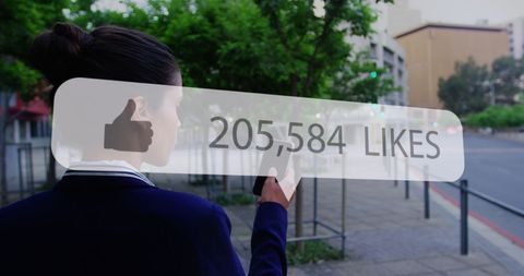 Woman Checking Social Media Notifications o­n Smartphone During Urban Walk