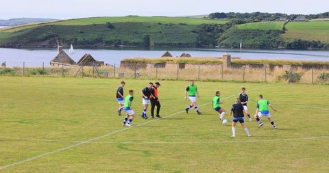 Soccer team practice by scenic riverside field