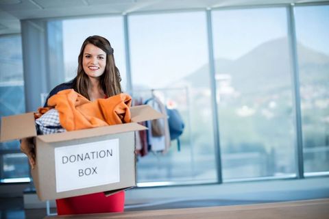 Woman Volunteering at Donation Center with Clothing Box