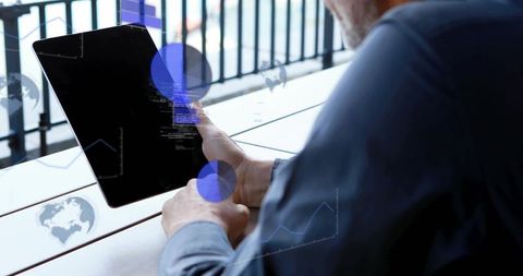 Senior man holding tablet and tapping while viewing digital data overlays on terrace