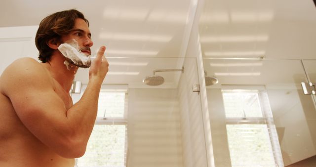 Young Man Shaving Beard in Modern Bathroom - Download Free Stock Images Pikwizard.com