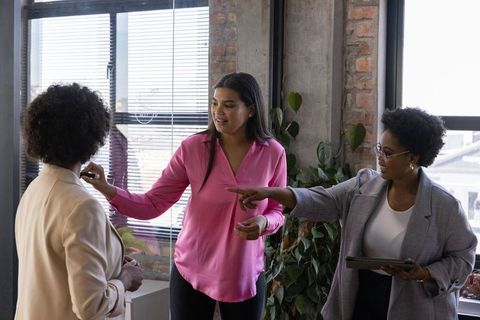 Diverse Coworkers Collaborating in Modern Office with Tablet