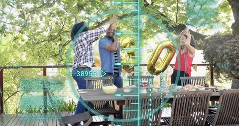 Friends putting party hats on deck celebrating with gold balloon numbers and hud