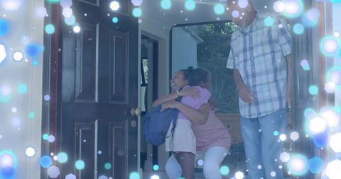 Grandparents welcoming granddaughter at front door embracing with backpack homecoming joy