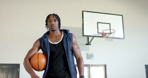 Confident Athlete Holding Basketball on Indoor Court