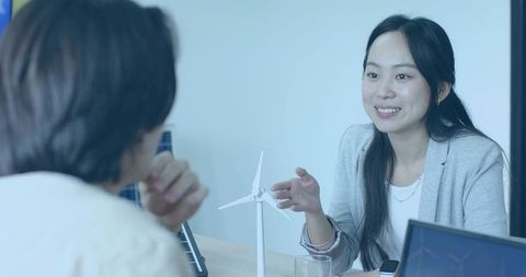 Asian businesswoman discussing wind energy with model