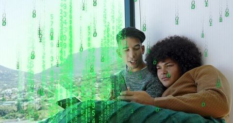 Young men reclining on sofa using tablet with green binary code overlay and city view