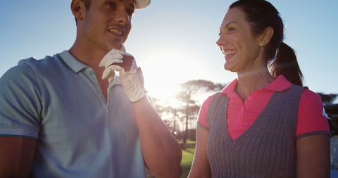 Happy couple enjoying golf game on sunny day