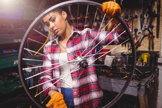 Mechanic examining a bicycle wheel in workshop