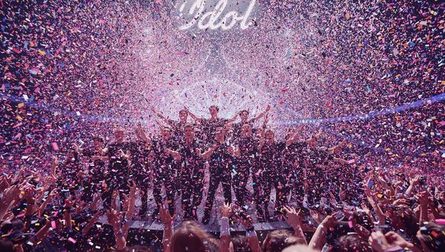Celebratory Performers on Stage with Vivid Confetti and Idol Sign