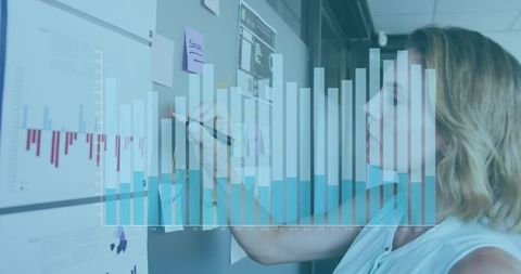 Businesswoman analyzing growth charts with data overlay