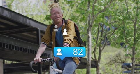 Man Cycling in Park with Social Influencer Notification