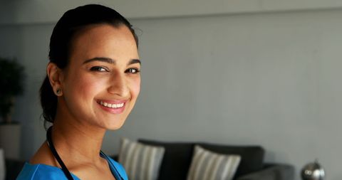 Smiling Female Doctor in Hospital Confidently Holding Stethoscope