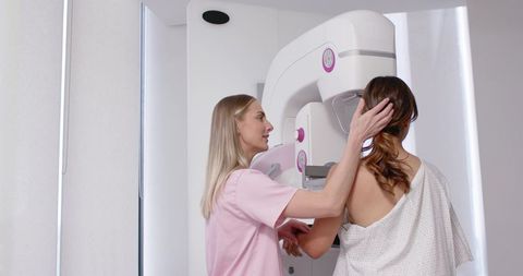 Female patient undergoing mammogram with supportive technician at breast imaging clinic
