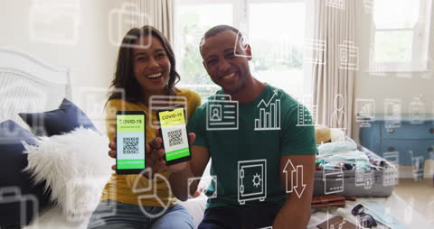Smiling Couple Holding COVID-19 Vaccine Passports on Smartphones