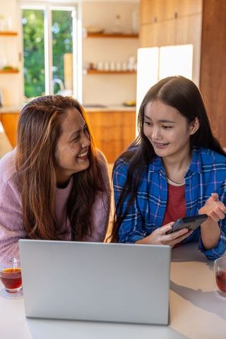 Asian Mother and Daughter Bonding at Home with Technology