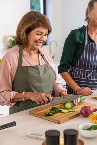 Senior women enjoying cooking together in cozy kitchen