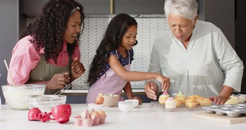 Multigenerational family decorating cupcakes together