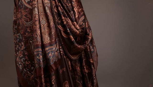Luxurious brown paisley silk shawl draped with rich folds and satin sheen for fashion