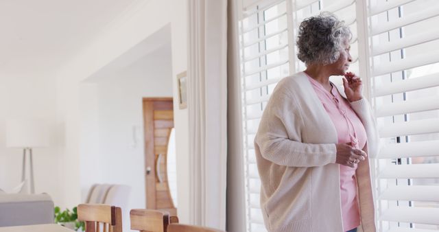 Senior Woman Looking Out Window, Contemplative Moment at Home - Download Free Stock Images Pikwizard.com