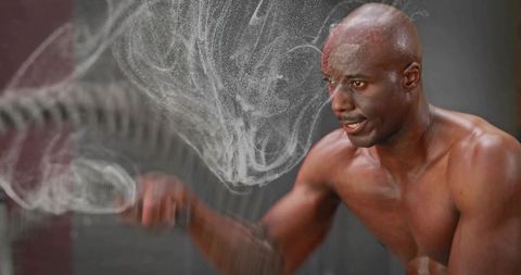 Shirtless athlete training with chalk cloud and powerful punch motion