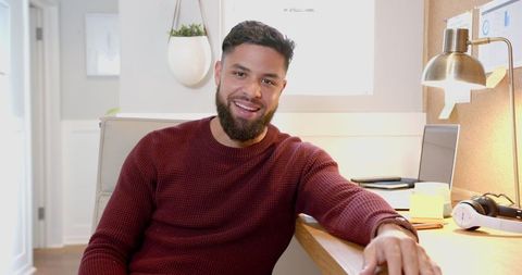 Man Smiling in Modern Home Office Working on Laptop