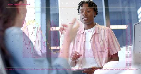 Colleagues analyzing financial data on tablet with virtual charts overlay during meeting