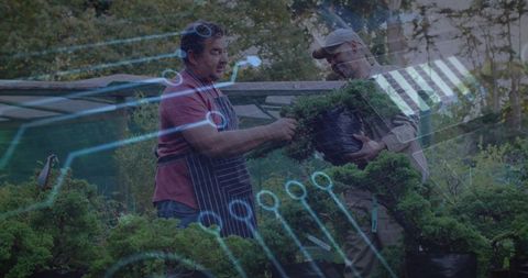 Gardeners examining potted shrub with circuit overlay illustrating smart horticulture teamwork