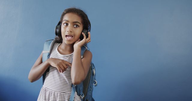 Young Girl Listening to Music with Headphones and Backpack - Download Free Stock Images Pikwizard.com