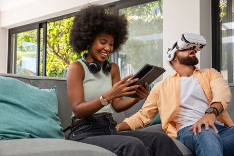 Friends enjoying virtual reality and technology gadgets indoors