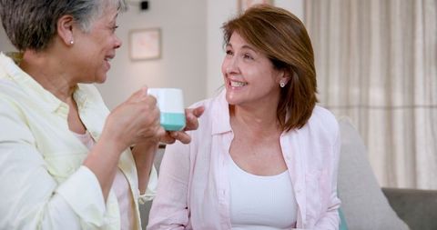 Senior Mother and Daughter Enjoying Tea Time Together in Cozy Home