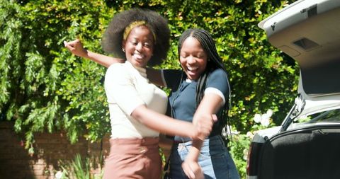 Sisters preparing car trunk for summer road trip