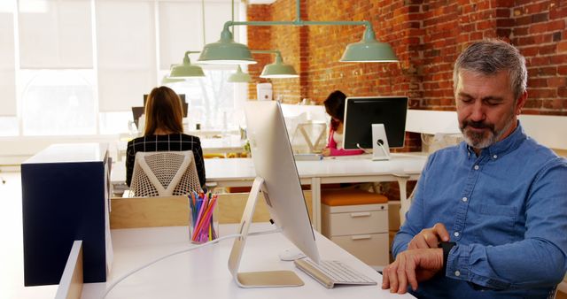 Modern Office with Employees Working and Man Checking Watch - Download Free Stock Images Pikwizard.com