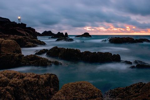 Tranquil coastal lighthouse at dawn with ocean waves