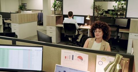 Diverse coworkers collaborating in modern office cubicles